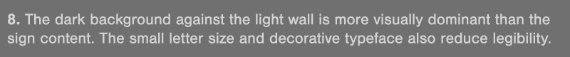 8  The dark background against the light wall is more visually dominant than the sign content  The small letter size    